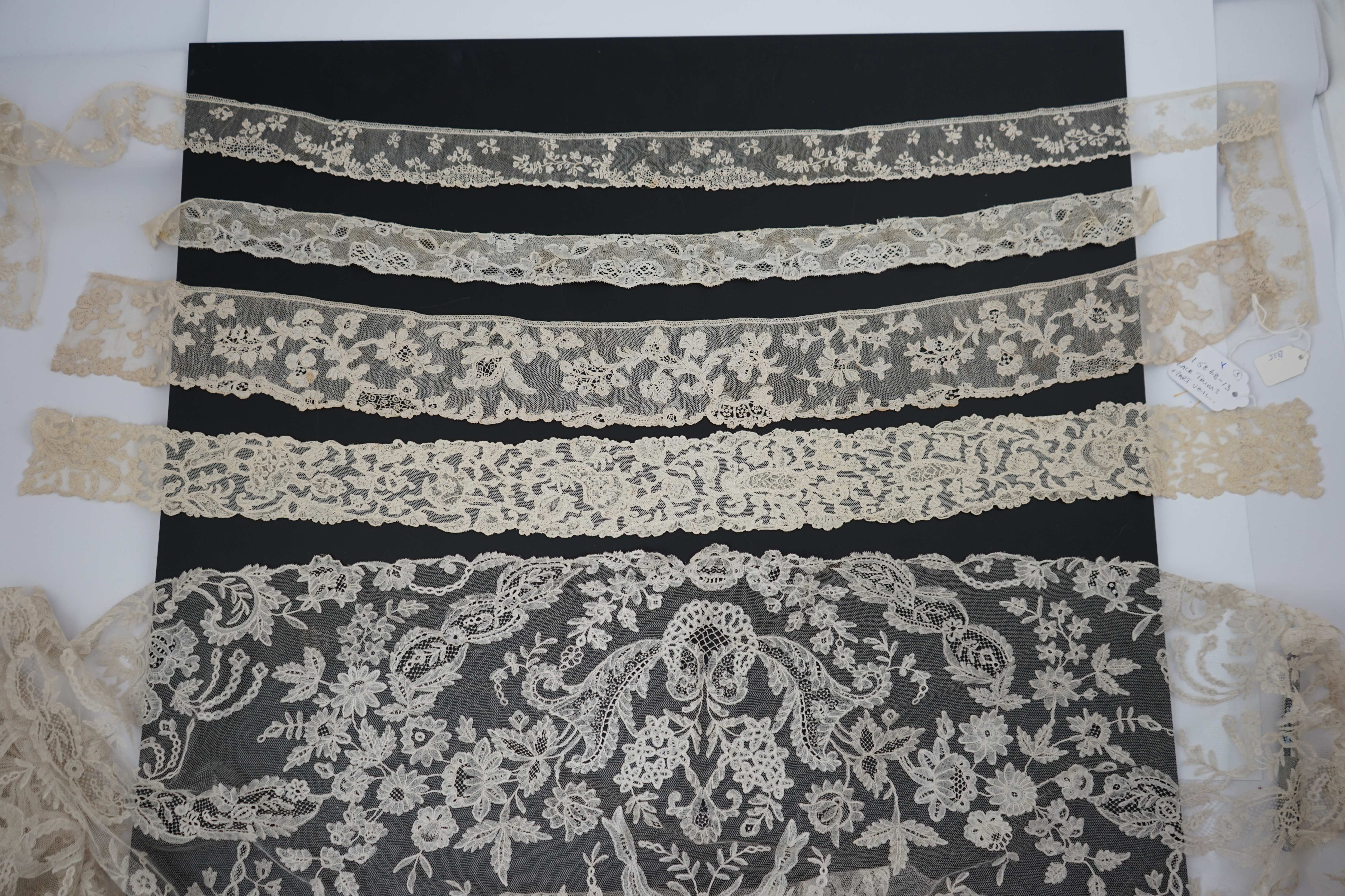 A large section of an ornate 19th century Brussels bobbin lace wedding veil, with two finished edges and one cut edge together with 18th century and later needle lace, an Argentan and an Alencon trimming, possibly an 18t